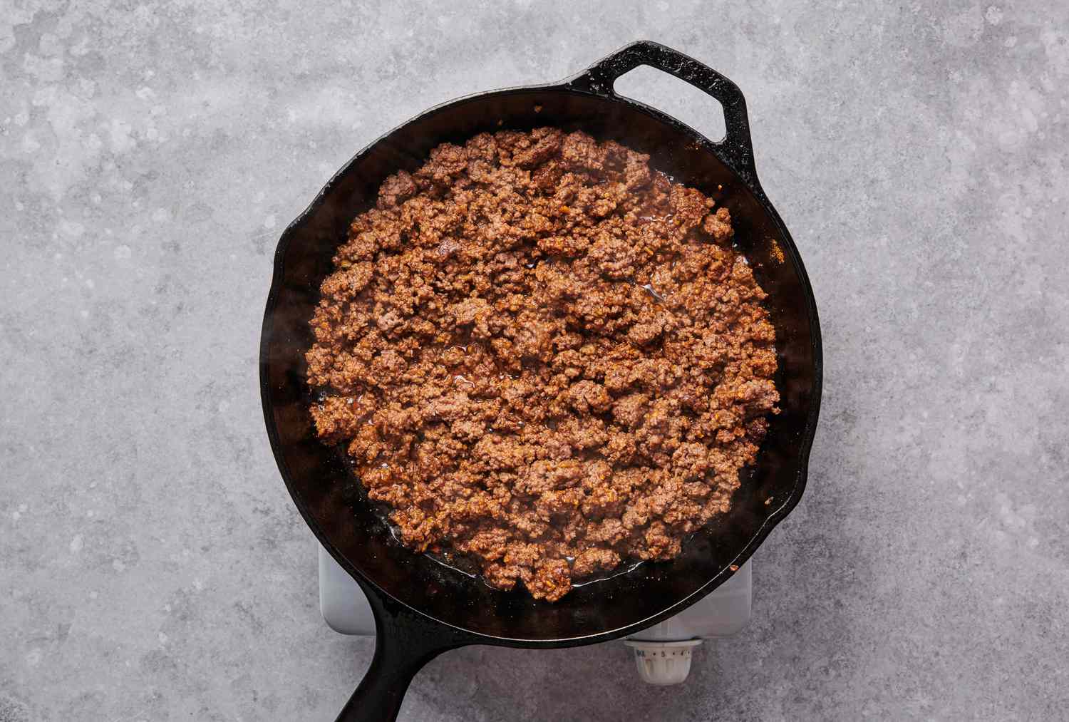 A skillet of cooked ground beef seasoned with taco seasoning