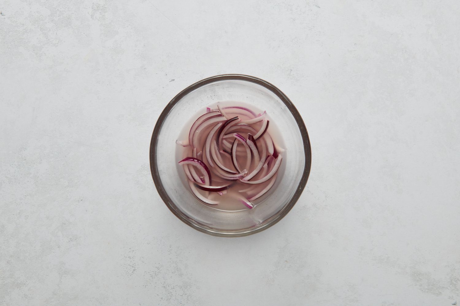 A small bowl of sliced red onions and lime juice