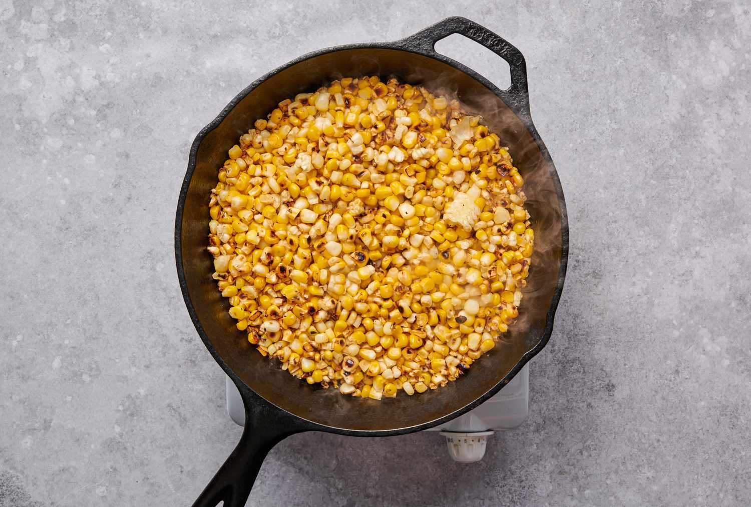 A large skillet of charred corn