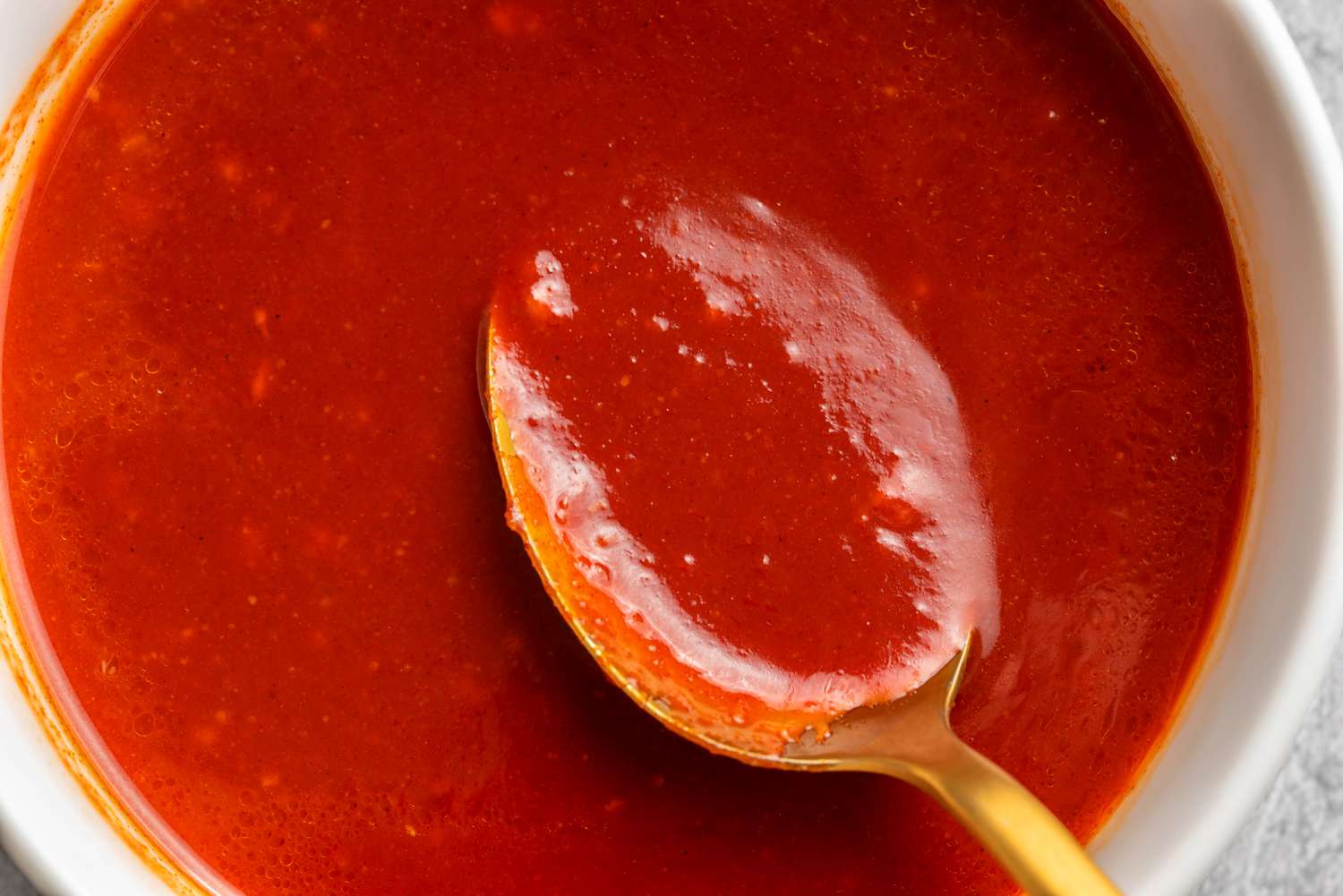 Bright red, thick Korean dipping sauce with a spoon in a bowl