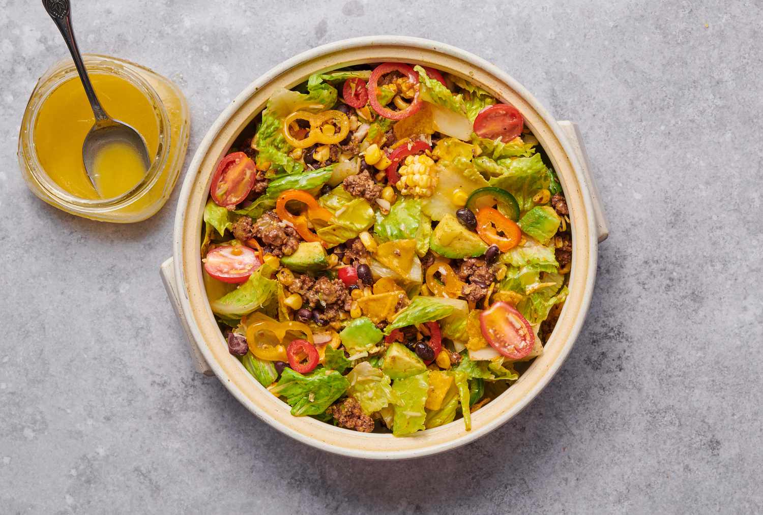 A large bowl of taco salad drizzled with dressing