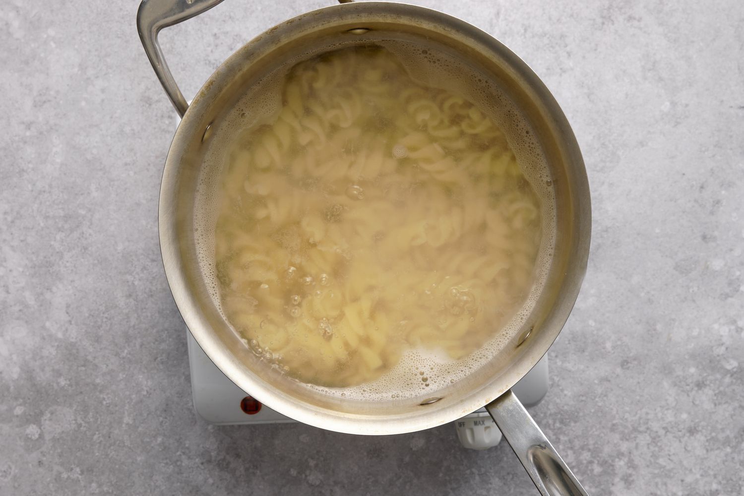 A large pot of fusilli pasta boiling in salted water