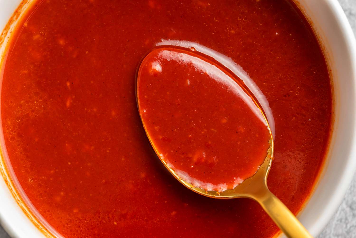 Bright red Korean dipping sauce with a spoon in a bowl