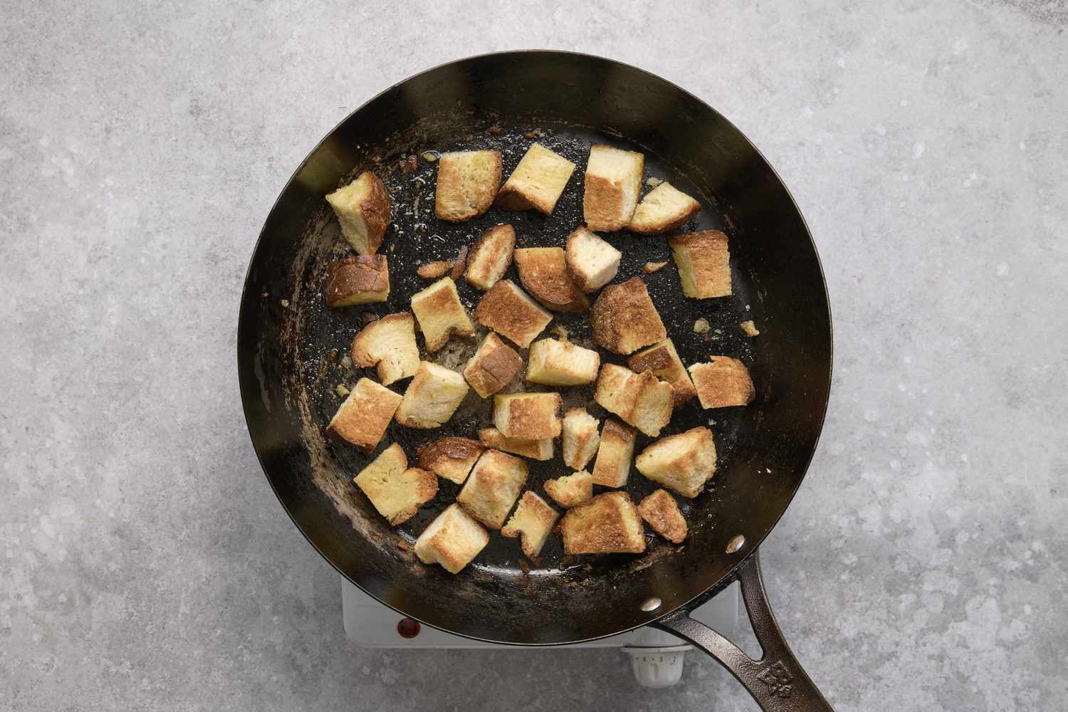 A skillet with toasted chunks of sourdough bread